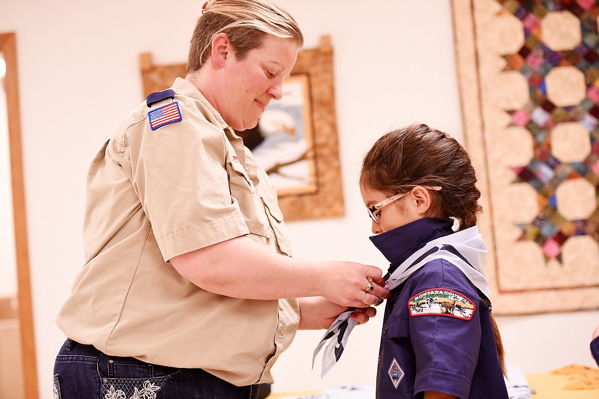 Arya Jepson gets her new scarf from Cubmaster Keri Barr in the Cub Scout Advancement ceremony on Monday, May 21.