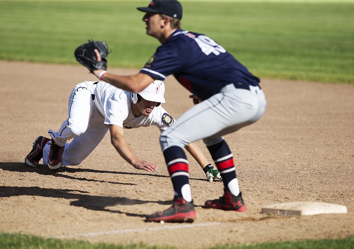 Prairie Cardinals baserunner Sam Schultz dives back to first base on a pickoff play against Coeur d&#146;Alene.