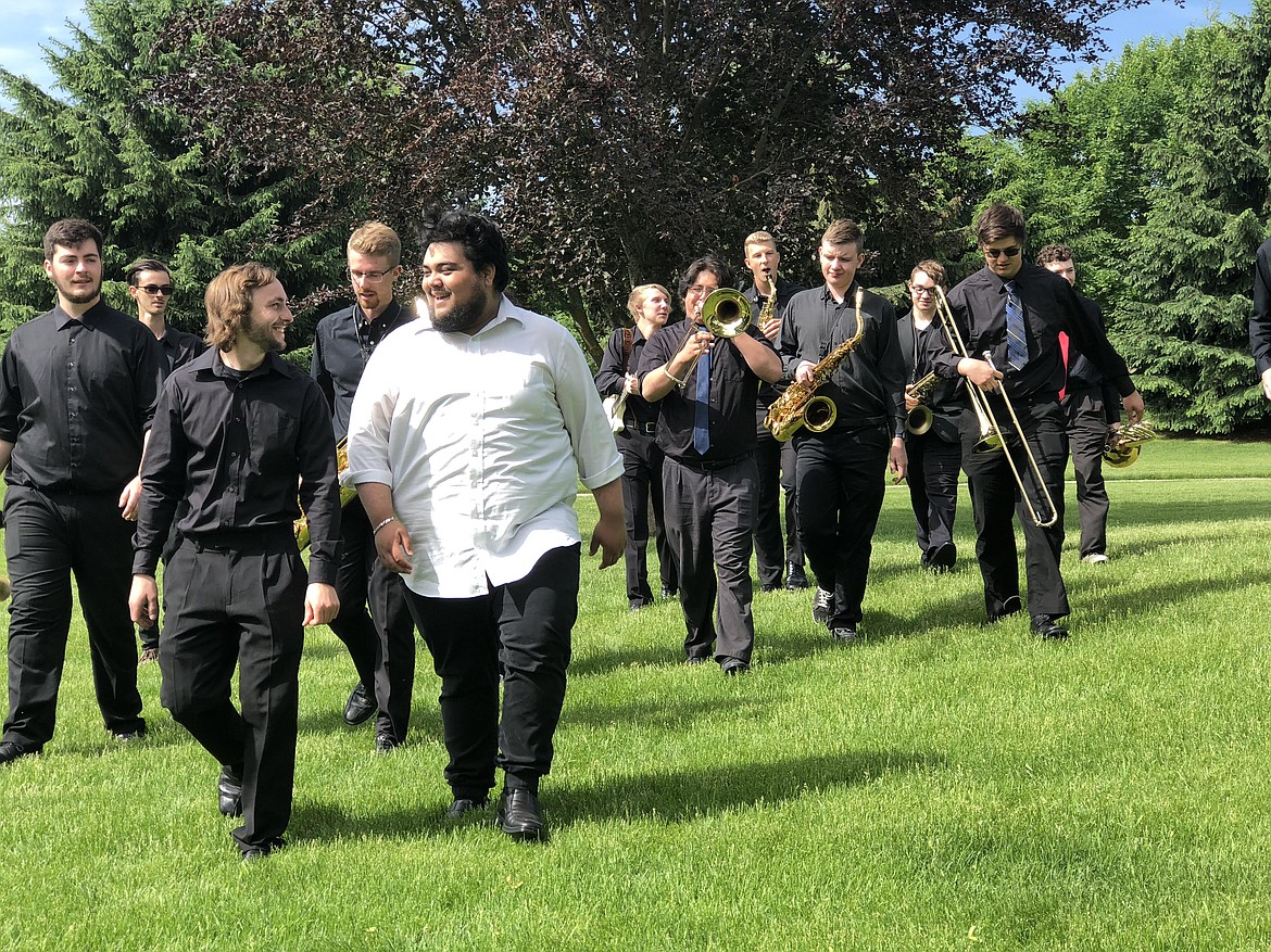 Lake City High School graduate Joseph Mataban, front right, walks with his band, the Mataban Jazz Experience, during a recent photo shoot. The nearly 20-piece big band comprises musicians between the ages of 18 and 24 who will be bringing their swinging sound to the Kroc Center for the Mataban Jazz Experience Live concert June 26. (Courtesy photo)