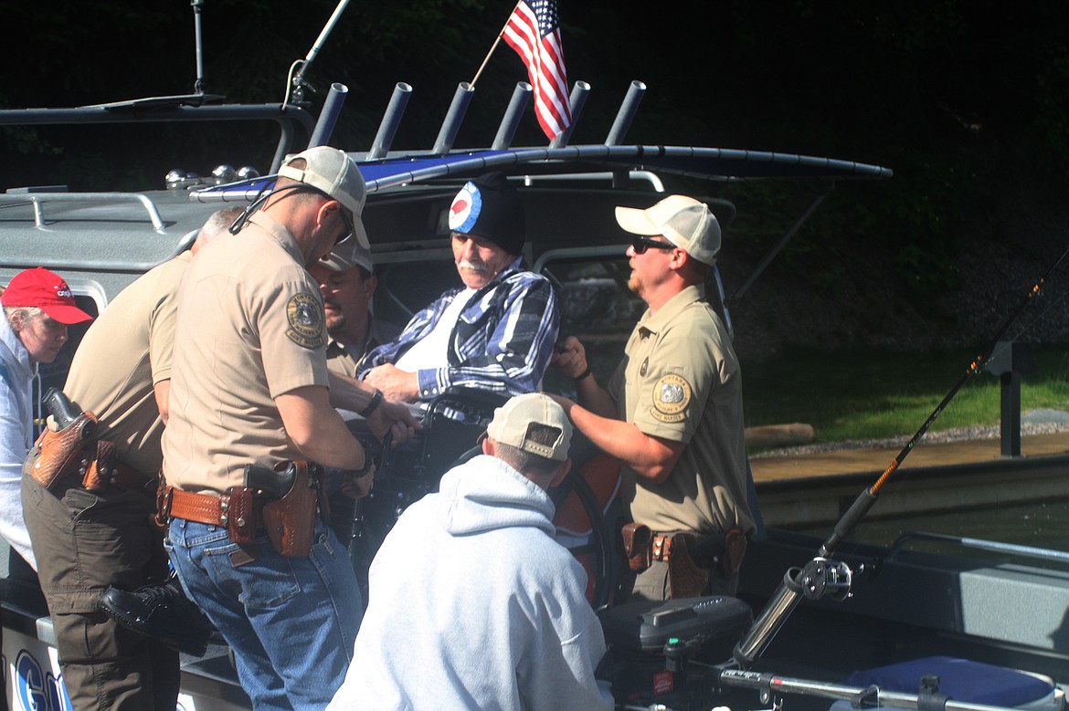 Montana Fish, Wildlife and Parks game wardens lift Ron Salazer aboard a Bagley Guide Service fishing boat at Woods Bay as part of the 25th Annual Jerry Howard Fishing Without Barriers Day on Flathead Lake. (Scott Shindledecker/Daily Inter Lake)