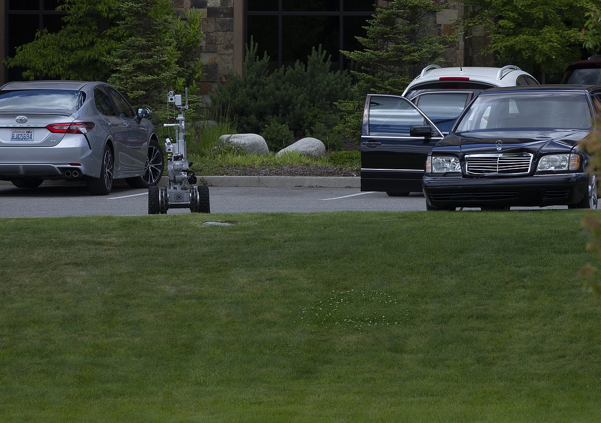 A spokane bomb squad robot investigates a suspicious car in the Hampton Inn parking lot in Riverstone on Monday. The search began when a man, who was not identified, had walked into the hotel lobby before noon and told employees there was a bomb in a car parked outside, according to Police. The man was taken to Kootenai Health for a psychological evaluation and the authorities called off the investigation around 2 p.m. (LOREN BENOIT/Press)