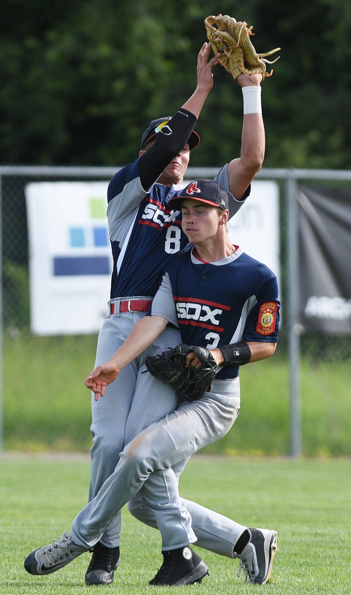 Bitterroot Red Sox left fielder Tucker Jones hangs on to a flyball for an out while colliding with shortstop Tanner Goligoski against the Kalispell Lakers A at Griffin Field on Tuesday. (Casey Kreider/Daily Inter Lake)