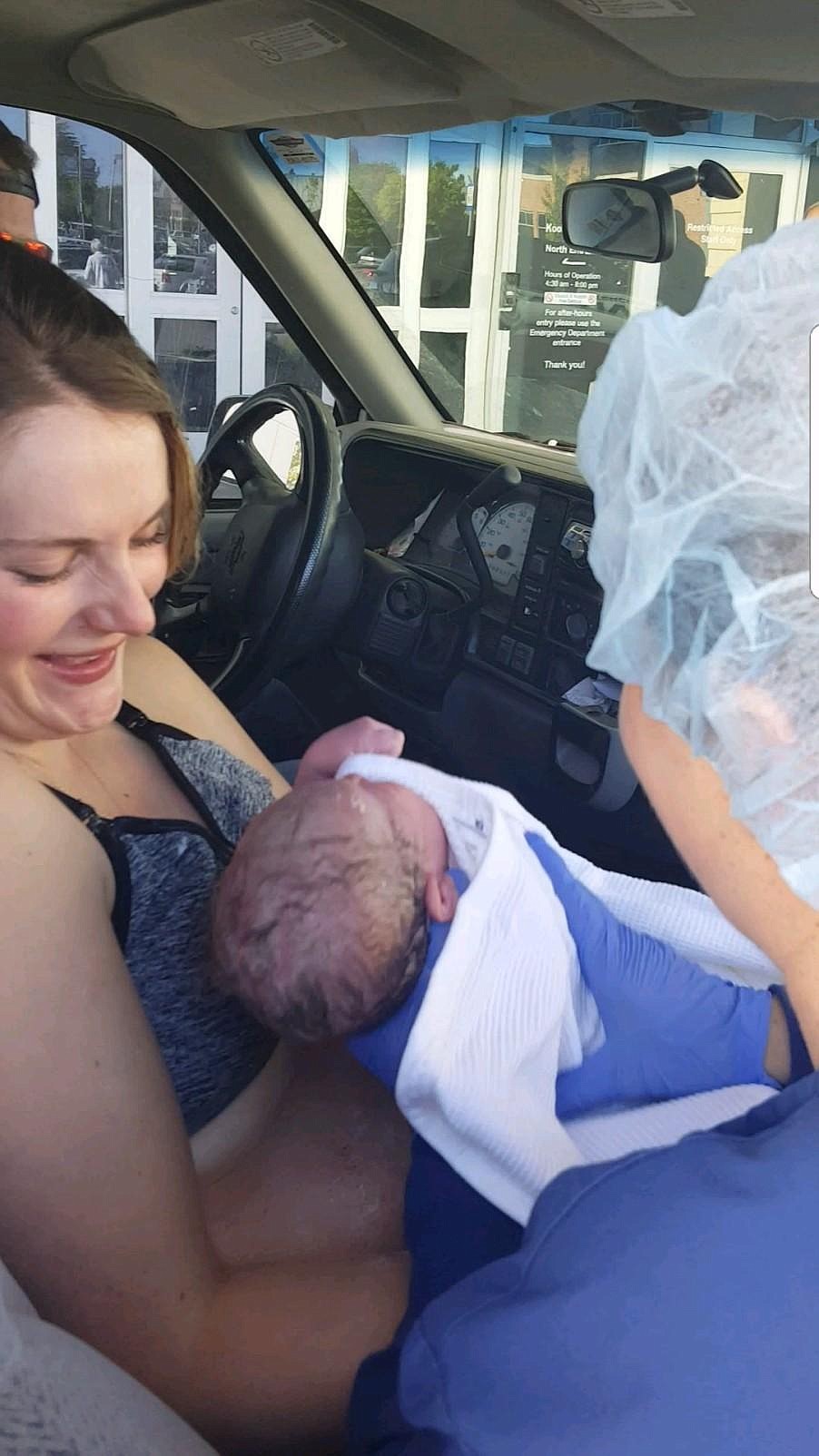 Haley Johnson looks down at her baby while sitting in the spot where she just gave birth, in the cab of a pickup truck driven by her husband, Cody. Kootenai Health employees met the new family in the parking lot when they arrived at the hospital. (Courtesy photo)