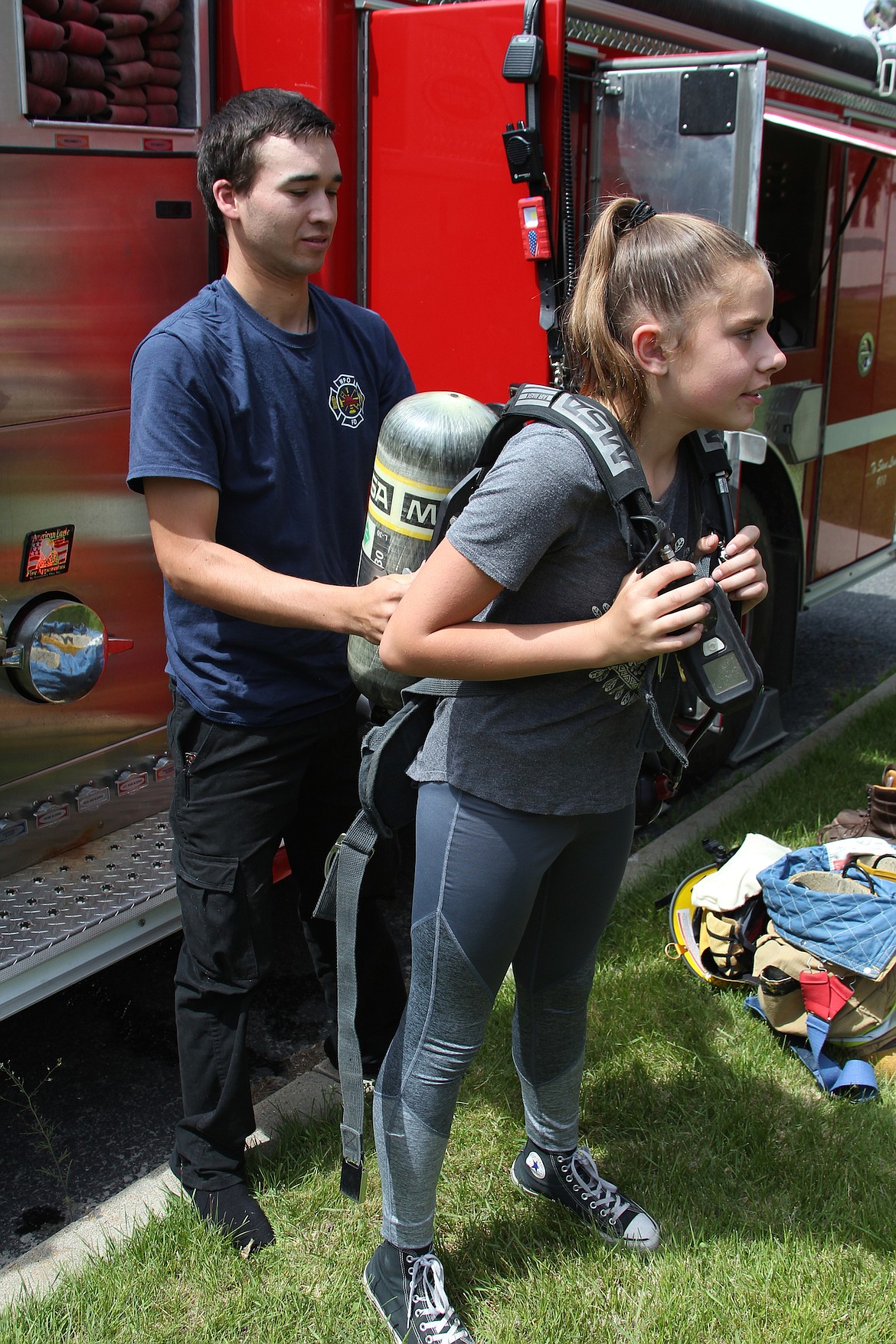 West Pend Oreille Firefighter Josh Malpica helps Idaho Hill Elementary student Emilee Favre try on a breathing apparatus during Public Safety Day on June 6.
(Photo by 
KEITH KINNAIRD)