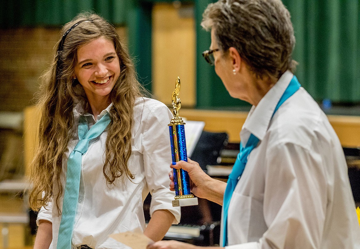 Choir Director Lorraine Braun, right, hands Mikalyn Zeiler a trophy recognizing her as MVP of the Women's Choir during an end-of-school-year event at the Libby Memorial Events Center May 22. (John Blodgett/The Western News)