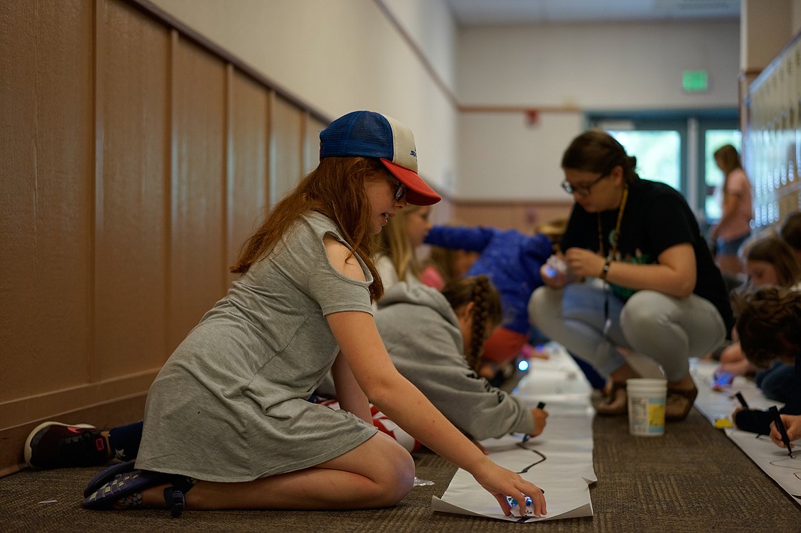 Annabelle Cubbage sets a car on a magnetic track at Camp Invention at Whitefish Middle School last week.