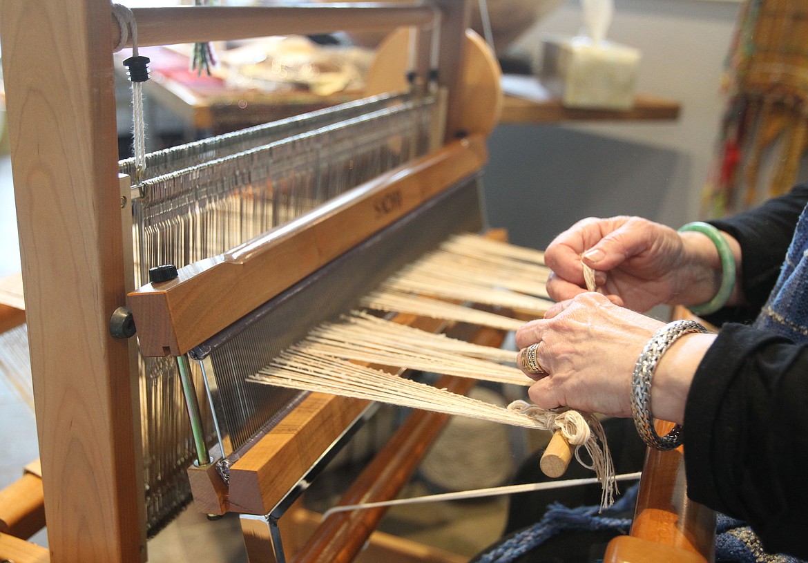 Fiber artist Sue Tye demonstrates how she creates unique fiber pieces on her Saori loom while participating in the Artists Studio Tour on Saturday. &quot;I love the creativity of just starting with string and bringing it together into something special,&quot; she said. (DEIVN WEEKS/Press)