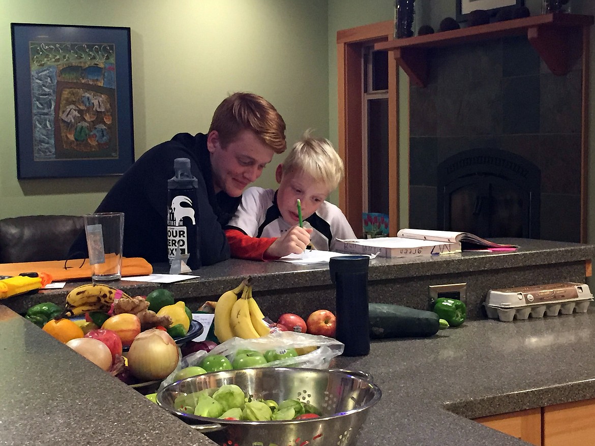 Columbia Falls exchange student Jakob Iken helps his host brother Ben Martin with his homework. (photo provided)