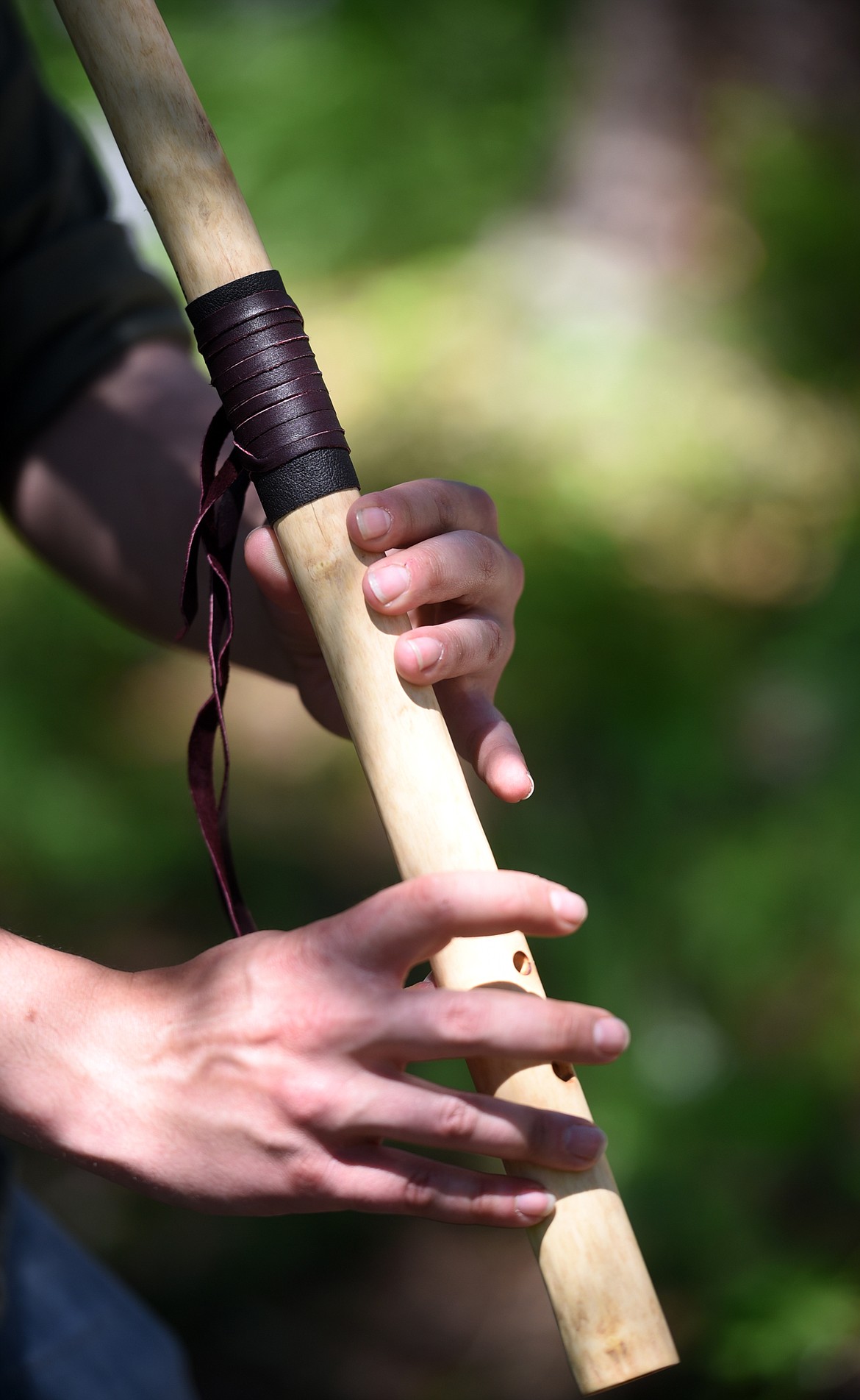 Niko Keys of Cedar Cabin Music demonstrates how he plays one of the flutes he made.(Brenda Ahearn/Daily Inter Lake)