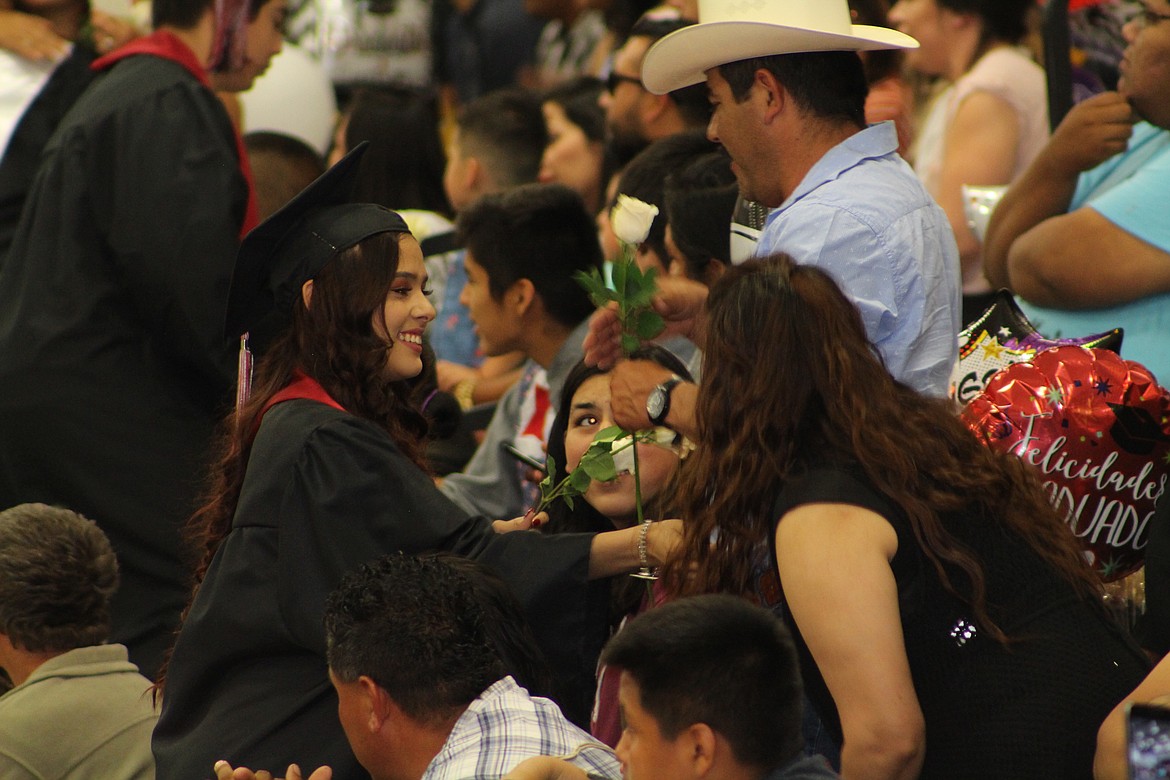 Chanet Stevenson/The Sun Tribune - A graduate presents her family with flowers during the graduation.