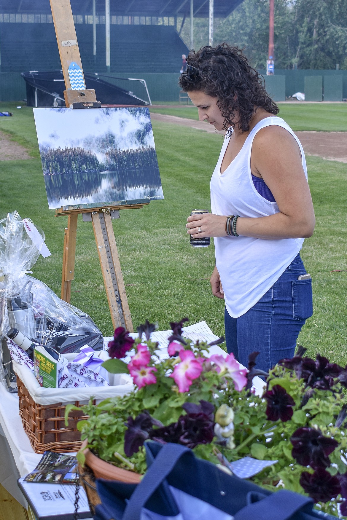 Liz Whalen checks out some of the silent auction items during the annual Dinner On The Diamond fundraiser at Lee Gehring Field on Friday. (Ben Kibbey/The Western News)