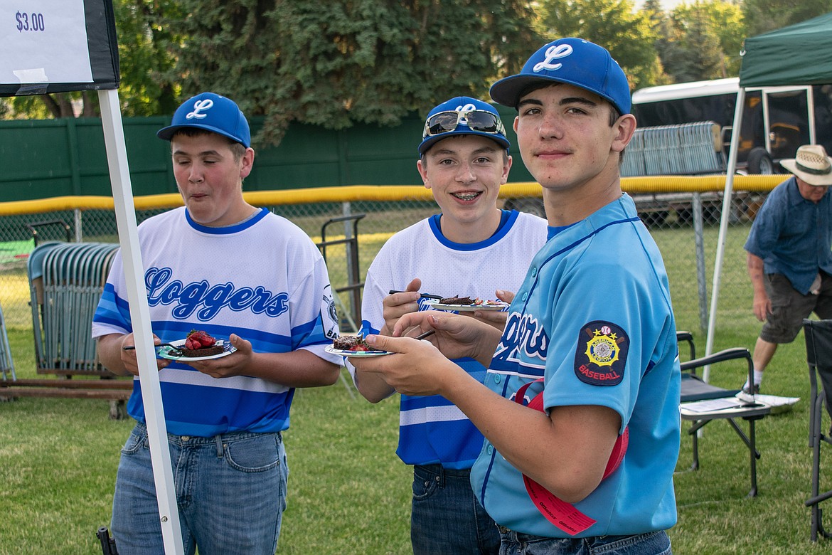Libby Loggers Austin McCully, Alex Svendsbye, and Trey Thompson take a quick break near the end of the annual Dinner On The Diamond fundraiser at Lee Gehring Field on Friday to try some of the brownies that were left over. (Ben Kibbey/The Western News)