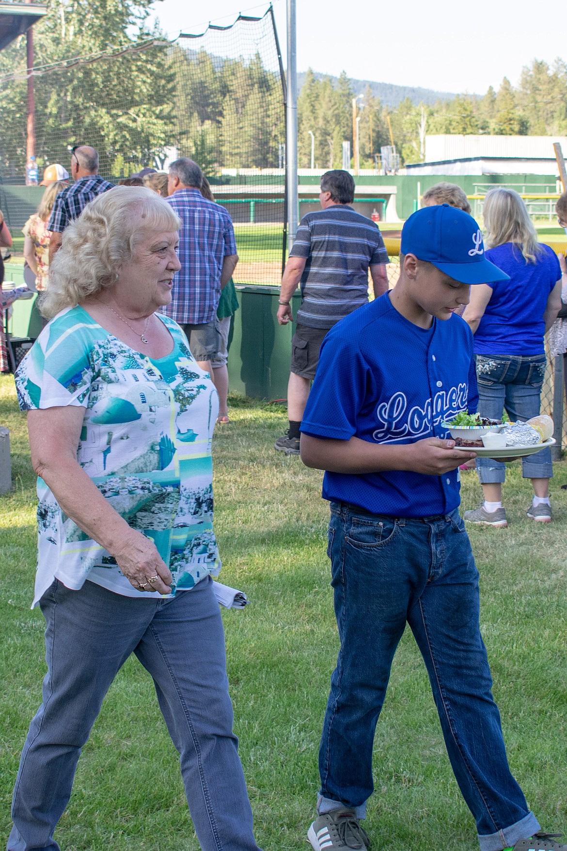 Libby Logger Kai Jenkins helps Anita Short to her seat during the annual Dinner On The Diamond fundraiser at Lee Gehring Field on Friday. (Ben Kibbey/The Western News)