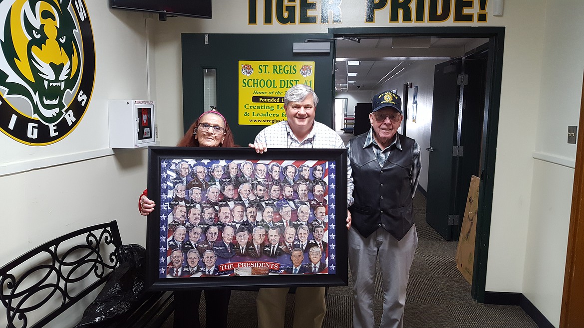 Joanie and Bill Merriman donated a large framed puzzle of U.S. presidents to St. Regis School. Superintendent Joe Steele (middle) said it will be hung in the government classroom. The Merrimans also donated a similar puzzle to Alberton and Superior School and the Mineral County Library. (Photo courtesy of Joe Steele)