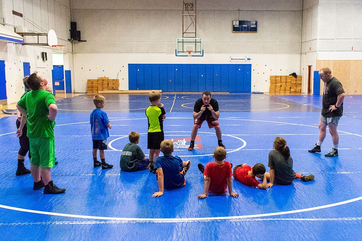 Stanford wrestling Head Coach Jason Borrelli and Eastern Michigan wrestling Head Coach David Bolyard instruct young wrestlers in a proper stance during the second annual Greenchain Wrestling Camp in Libby on Saturday.  (Benjamin Kibbey/The Western News)