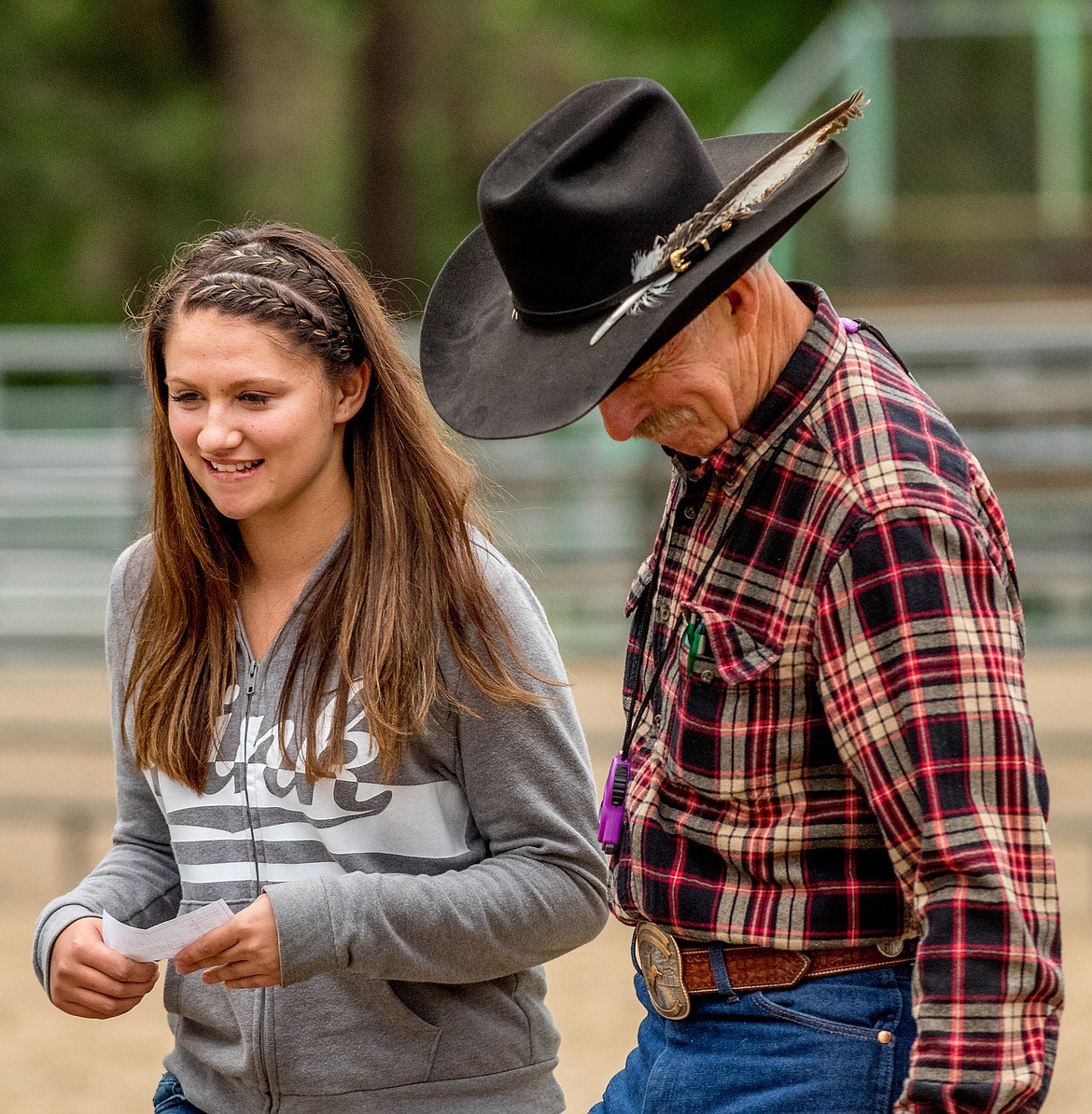 Libby High School graduate Haylee Cannon, left, was presented with a $1,000 scholarship by Incredi-Bull committee chairman Brett Bronson, right, during Saturday night's event at J. Neils Park in Libby. (John Blodgett/The Western News)