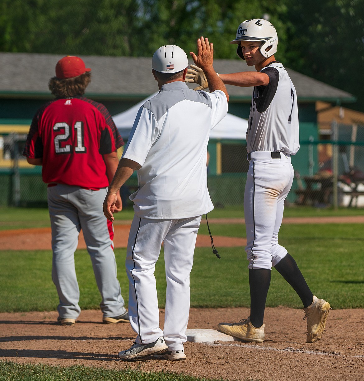 Terek Bistodeau high fives coach Scott Murray after a base hit Friday against the Kalispell Lakers A.