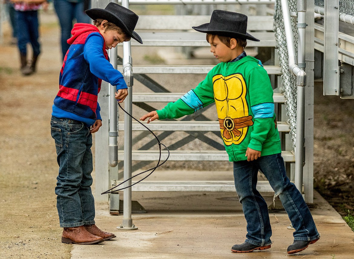 Joshua Wolfe, left, and Preston Stringer play with a small lasso before the start of Incredi-Bull at J. Neils Park in Libby Saturday, June 9, 2018. (John Blodgett/The Western News)