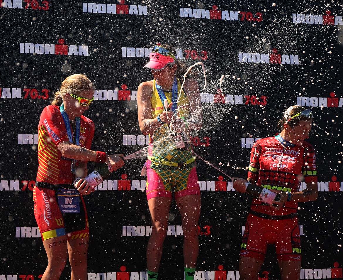 Second place women's Ironman finisher Sarah Piampiano, left, and third place finisher Linsey Corbin, right, shower Haley Chura with champaign. (LOREN BENOIT/Press)