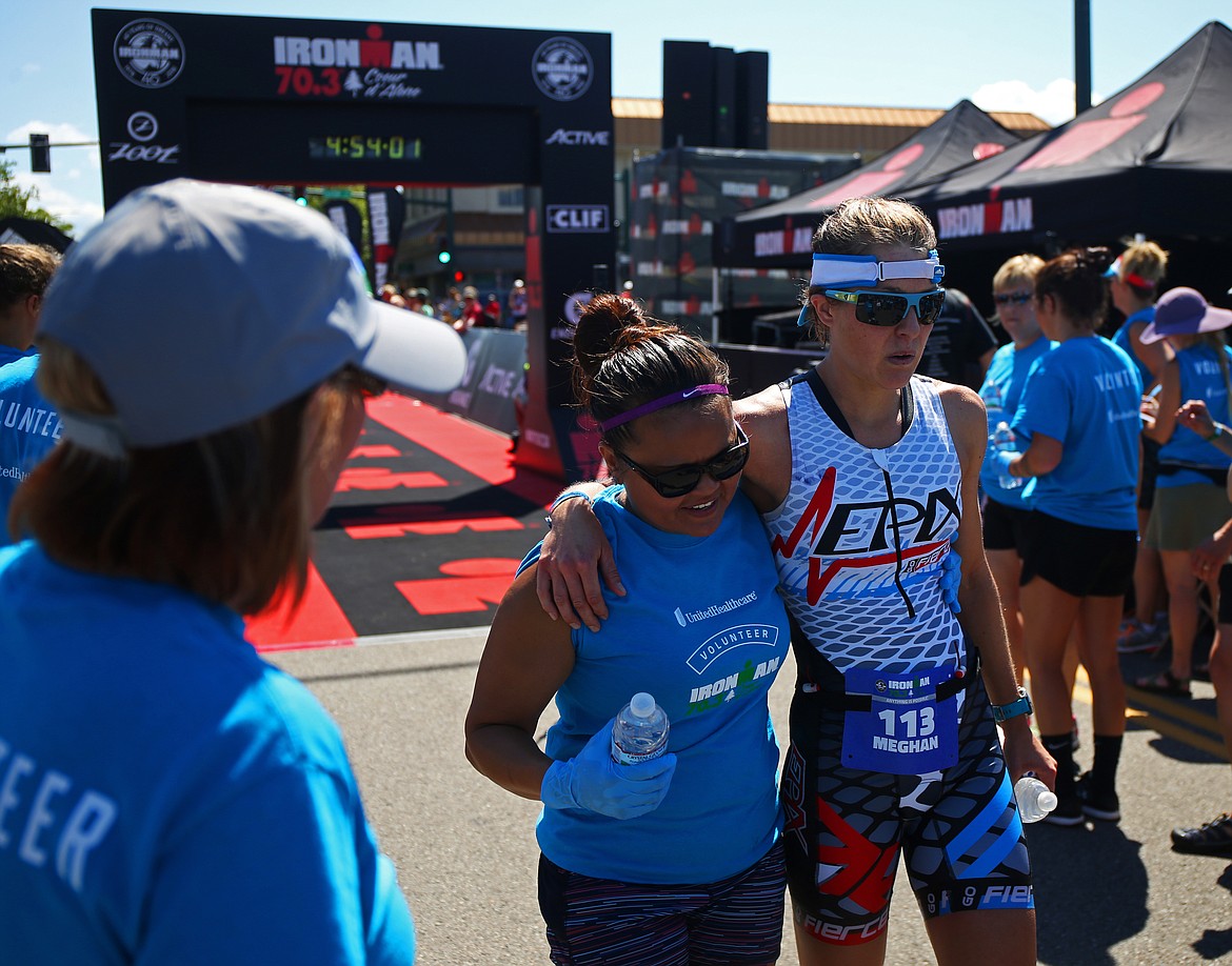 LOREN BENOIT/Press
Ironman volunteer Jena Meyer helps athlete Meghan Faulkenberry at the finish line of the Ironman 70.3 on Sunday in downtown Coeur d&#146;Alene.