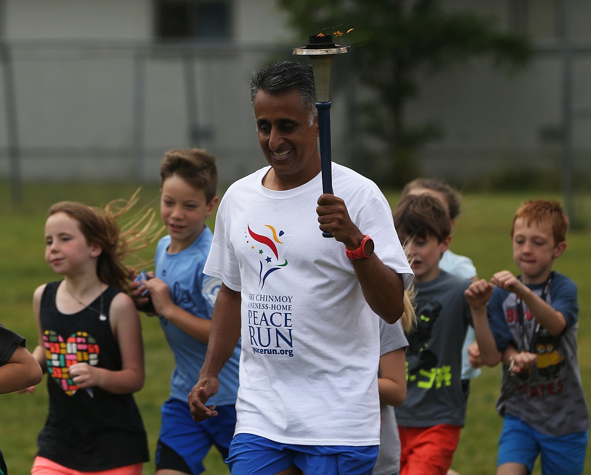 Sanjay Rawal, from india, goes for a run with kids around the Boys and Girls Club property in Coeur d&#146;Alene on Friday. Around 50,000 children in more than 1,000 cities will participate in the country-wide relay in which runners from Sri Chinmoy Oneness-Home Peace Run will provide educational presentations to promote self-esteem and unity among school children and youth organizations. (LOREN BENOIT/Press)