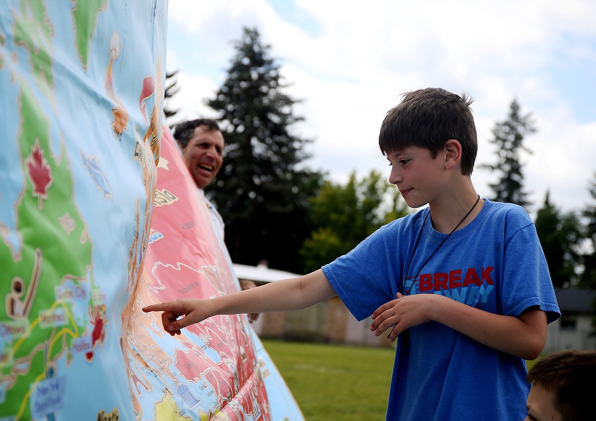 Adan Jonz points out Austria on a world map during a geography lesson with the the Sri Chinmoy Oneness-Home Peace Run group at the Boys and Girls Club in Coeur d&#146;Alene on Friday. (LOREN BENOIT/Press)