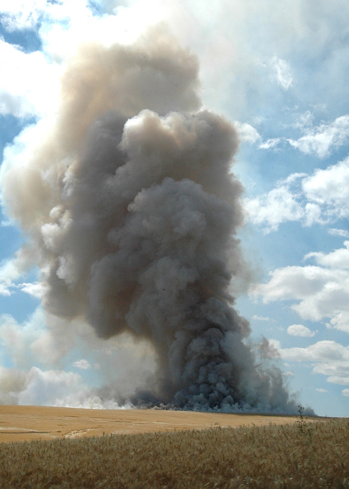 FILE - In this Aug. 6, 2009, file photo, the stubble of a grain field on the Camas Priaire is burned after the harvest producing a heavy plume of smoke in Lewiston, Idaho. Federal officials have approved Idaho's request to loosen field burning rules that backers say offer more flexibility to disperse smoke away from people but that health advocates say will lead to breathing problems for some area residents. The U.S. Environmental Protection Agency earlier this week issued a final rule that allows field burning in the state during worse air quality thresholds for ozone starting July 19, 2018. (Barry Kough /Lewiston Tribune via AP, File)