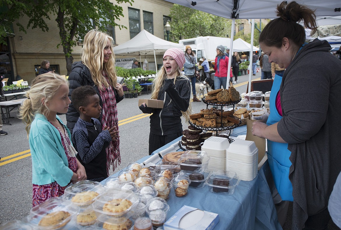 Andria Howes of Lake City Cakes bags up treats for the Stam family at the Kootenai County Downtown Farmers Market. (LISA JAMES/Press File Photo)