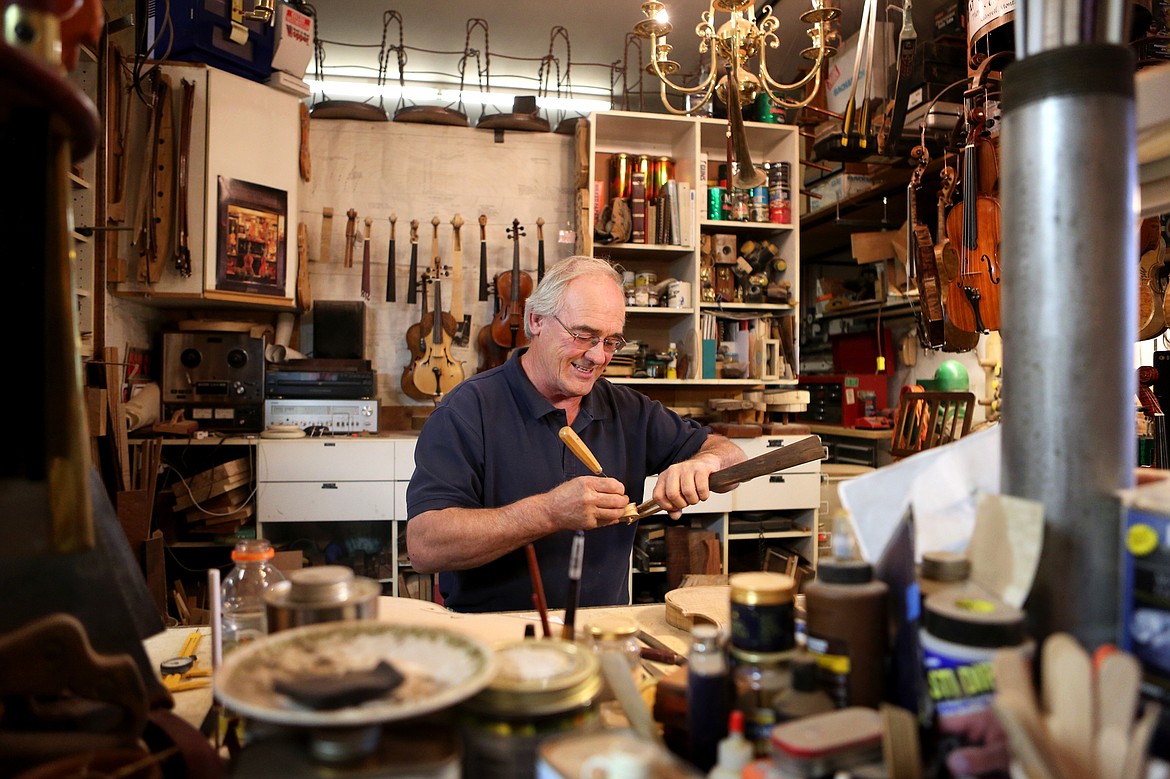 Tom Simensen works on a violin at his shop in Kalispell. (Mackenzie Reiss/Daily Inter Lake)