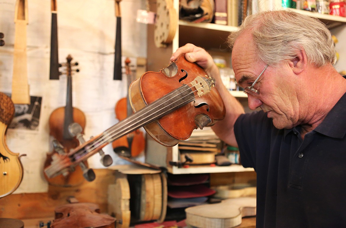 Tom Simensen inspects one of his creations on Monday. Simensen has crafted around 25 violins since he started making instruments in the 1990s.