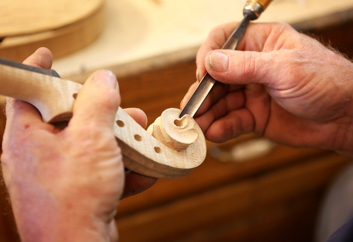 Simensen carves the scroll of a violin inside his Kalispell shop.