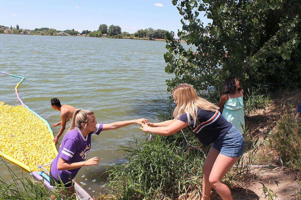 Joel Martin/Columbia Basin Herald
Miranda Herrera, left, hands the first-place quacker to Chloe Chase at the Duck Derby Saturday.