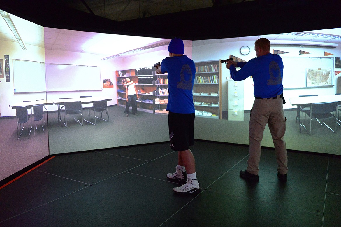 Josh Stevens, left, and Kalispell Police Department officer Jason Parce participate in a school shooting simulation during the department's Junior Academy at Northwest Shooter on Friday. (Casey Kreider/Daily Inter Lake)