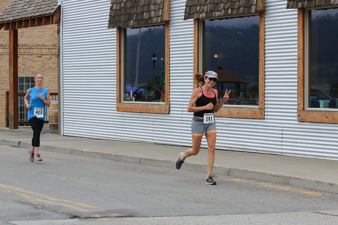 Photo by MANDI BATEMAN
Carolyn Testa, followed by Kelly Allen, heading for home in front of the Kootenai Brewing Company.