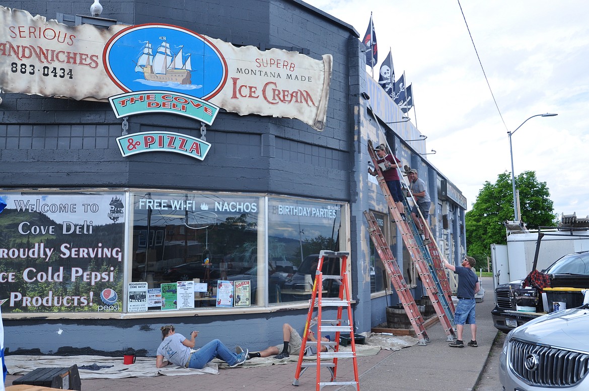 CREWS FROM Fisher Painting work on The Cove Deli &amp; Pizza in Polson Thursday, June 21. The team hand-painted the facade and caulked the windows. (Ashley Fox/Lake County Leader)