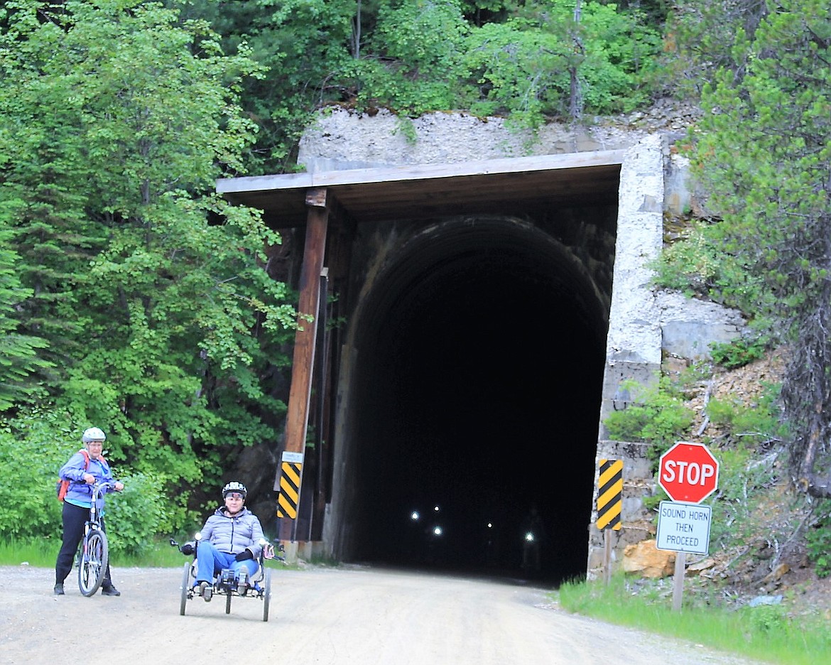 LIGHTS ON bicycles peer out of a dark tunnel along the Route of the Hiawatha. Eight tunnels are part of the route, located near the Montana/Idaho state line.