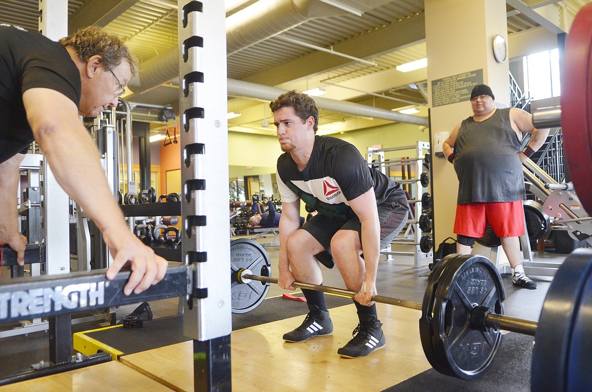 Chandler Krahn does a deadlift during a practice session at The Wave while coach Mark Kuhr, left, watches. (Heidi Desch/Whitefish Pilot)