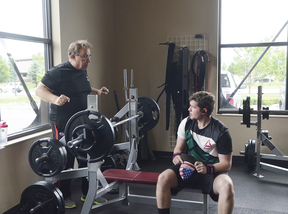 Coach Mark Kuhr gives athlete Chandler Krahn some pointers during a workout at The Wave last week. Krahn will compete in powerlifting at the Special Olympic United States Games in Seattle. (Heidi Desch/Whitefish Pilot)