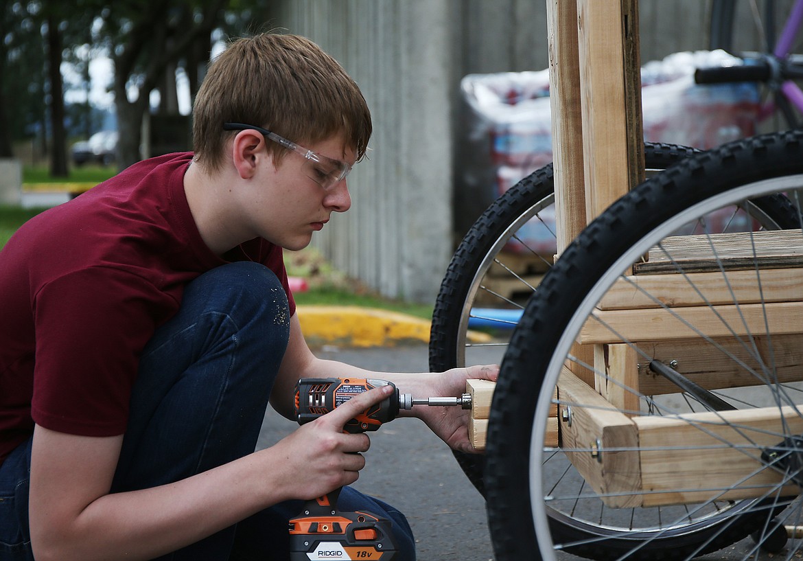 Alex Monter installs a wooden mount for a cart Thursday afternoon at Gizmo-CDA. Monter, and many others like him, will unveil their man-powered creations at this year's fourth annual GizMotion parade on Saturday July 7 in City Park. (LOREN BENOIT/Press)