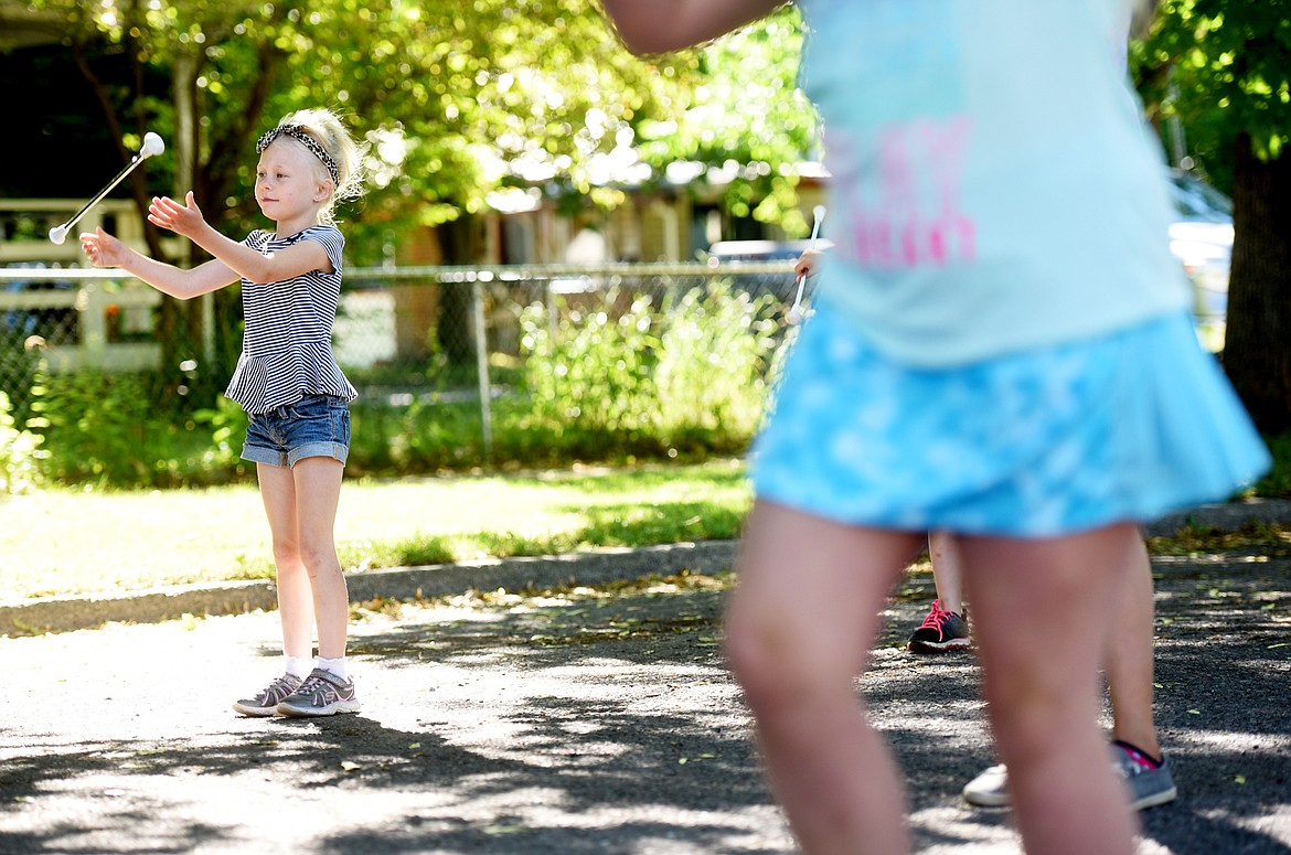 Olive Louk, catches her baton as she and members of the Treasure State Twirlers practice outside Hedges Elementary on Tuesday morning, June 26. (Brenda Ahearn/Daily Inter Lake)