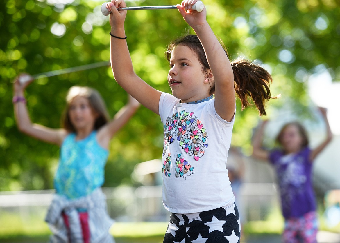 Finley Kipp and members of the Treasure State Twirlers practice outside Hedges Elementary on Tuesday morning, June 26. (Brenda Ahearn/Daily Inter Lake)