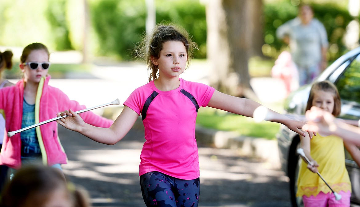 Mya Presnell and members of the Treasure State Twirlers practice outside Hedges Elementary on Tuesday morning, June 26. (Brenda Ahearn/Daily Inter Lake)