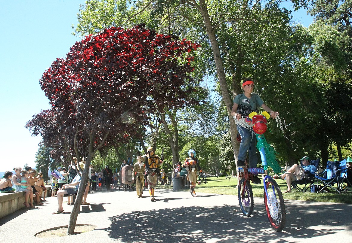 Noah Dugall, 14, of Coeur d'Alene, rides a decked-out double-decker bike in the Gizmotion parade as spectators take photos and smile at the procession of creativity Saturday afternoon. A fleet of &quot;Star Wars&quot; characters and vehicles followed behind Noah, along with several youths on decorated bikes. (DEVIN WEEKS/Press)