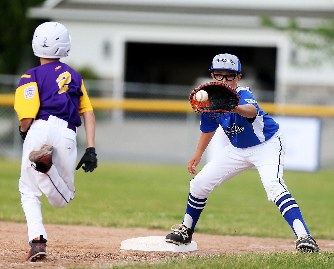 Coeur d&#146;Alene&#146;s Cooper Smith fields a throw from catcher Avery Cherry as Lewiston&#146;s Teigen Abell runs up the baseline in a Little League Majors District 1 tournament game at Canfield Sports Complex. (LOREN BENOIT/Press)