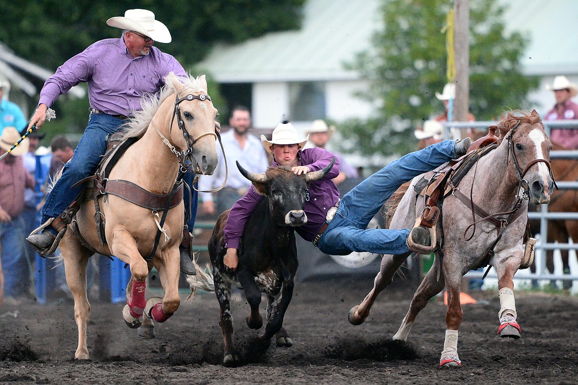 Kris Anderson, center, of Hamilton, competes during the Steer Wrestling event at the Bigfork Summer Pro Rodeo on Friday. (Casey Kreider/Daily Inter Lake)