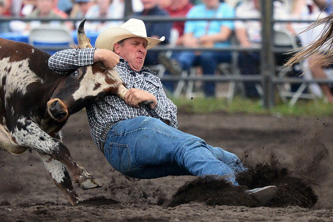 Hank Hollenbeck, of Molt, takes a steer to the ground during the Steer Wrestling event at the Bigfork Summer Pro Rodeo on Friday. (Casey Kreider/Daily Inter Lake)