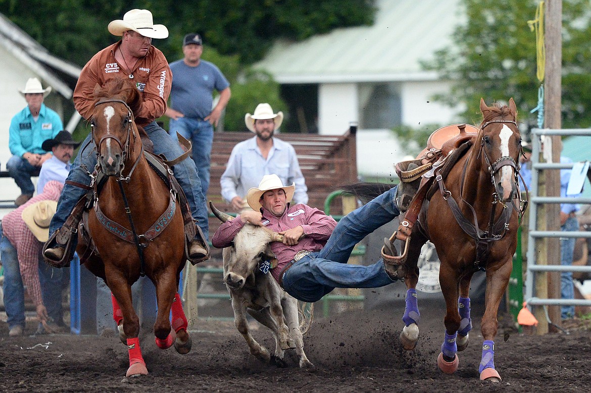 Scott Guenthner, center, of Provost, Alberta, Canada, competes during the Steer Wrestling event at the Bigfork Summer Pro Rodeo on Friday. (Casey Kreider/Daily Inter Lake)