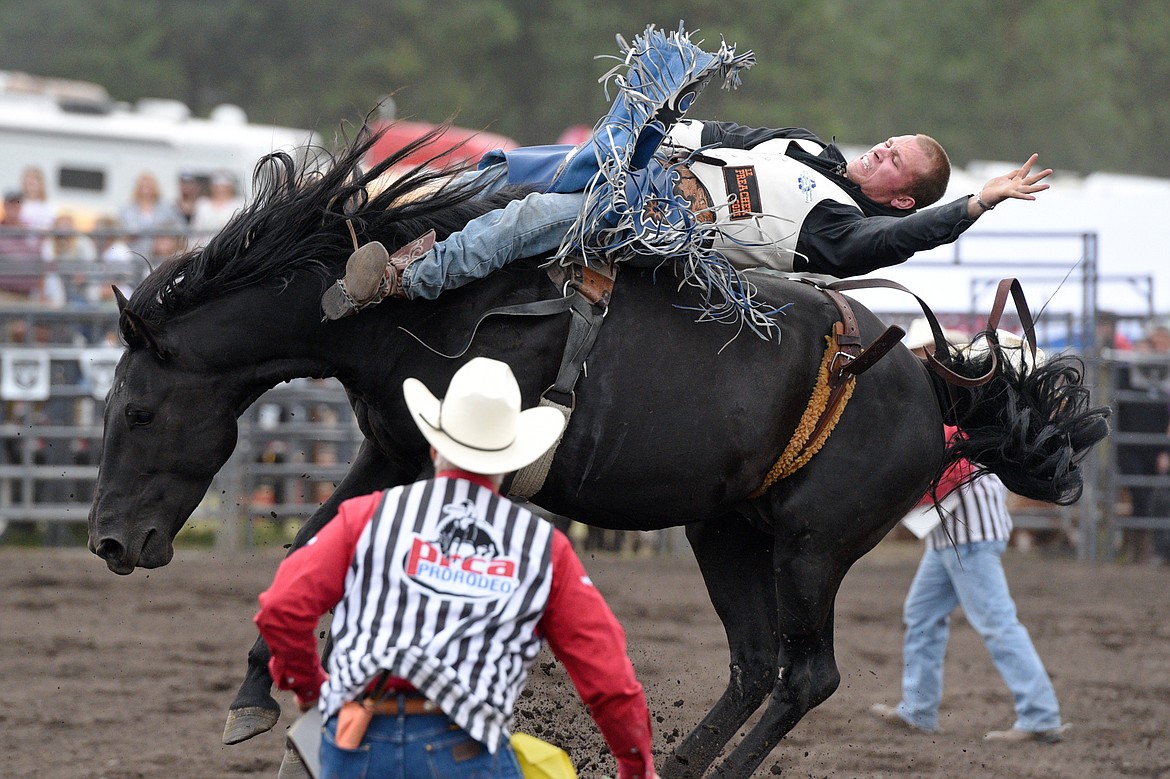 Pascal Isabelle, of Okotoks, Alberta, Canada, hangs on to his horse Midnight Dolly during the Bareback Riding event at the Bigfork Summer Pro Rodeo on Friday. (Casey Kreider/Daily Inter Lake)