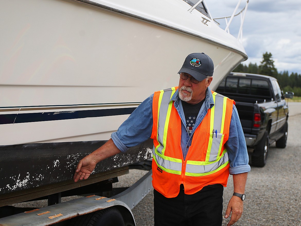 Arn Powell, with the Idaho State Department of Agriculture, inspects a boat on Highway 53 near the state line on Tuesday. (LOREN BENOIT/Press)