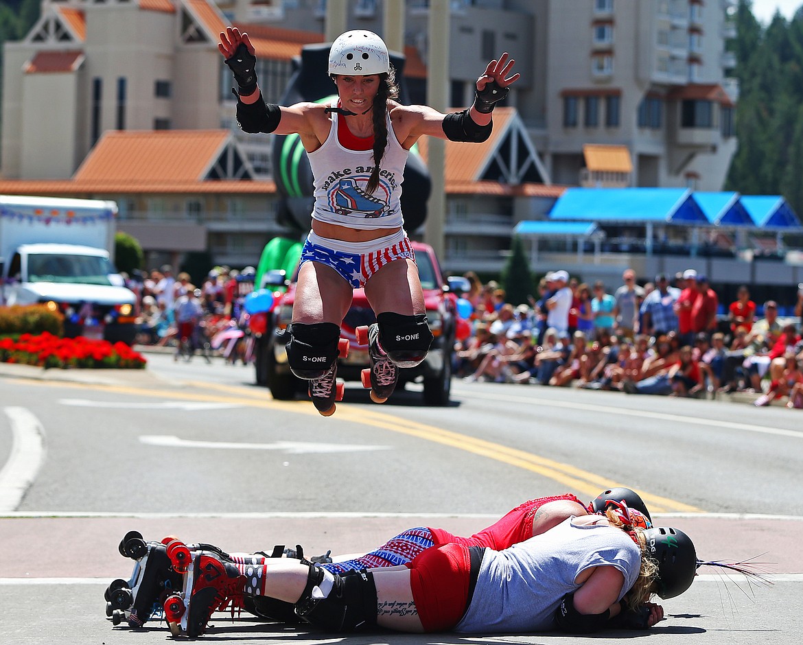 Samantha Houseman, a.k.a Seymour Guts, leaps over fellow Snake Pit Derby Dames during the Fourth of July parade on Wednesday. (LOREN BENOIT/Press)